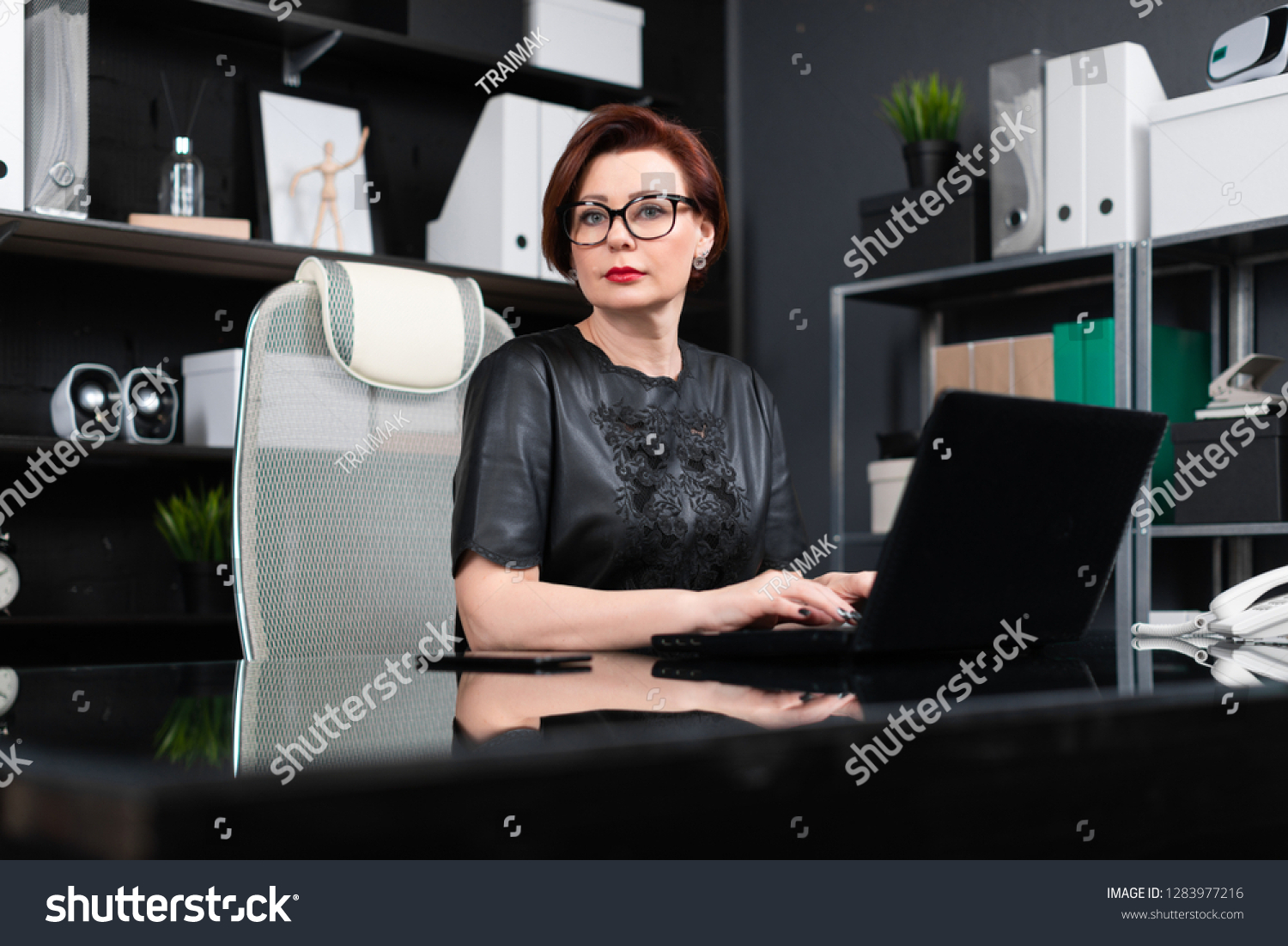 Portrait of strict businesswoman with laptop in stylish office #1283977216
