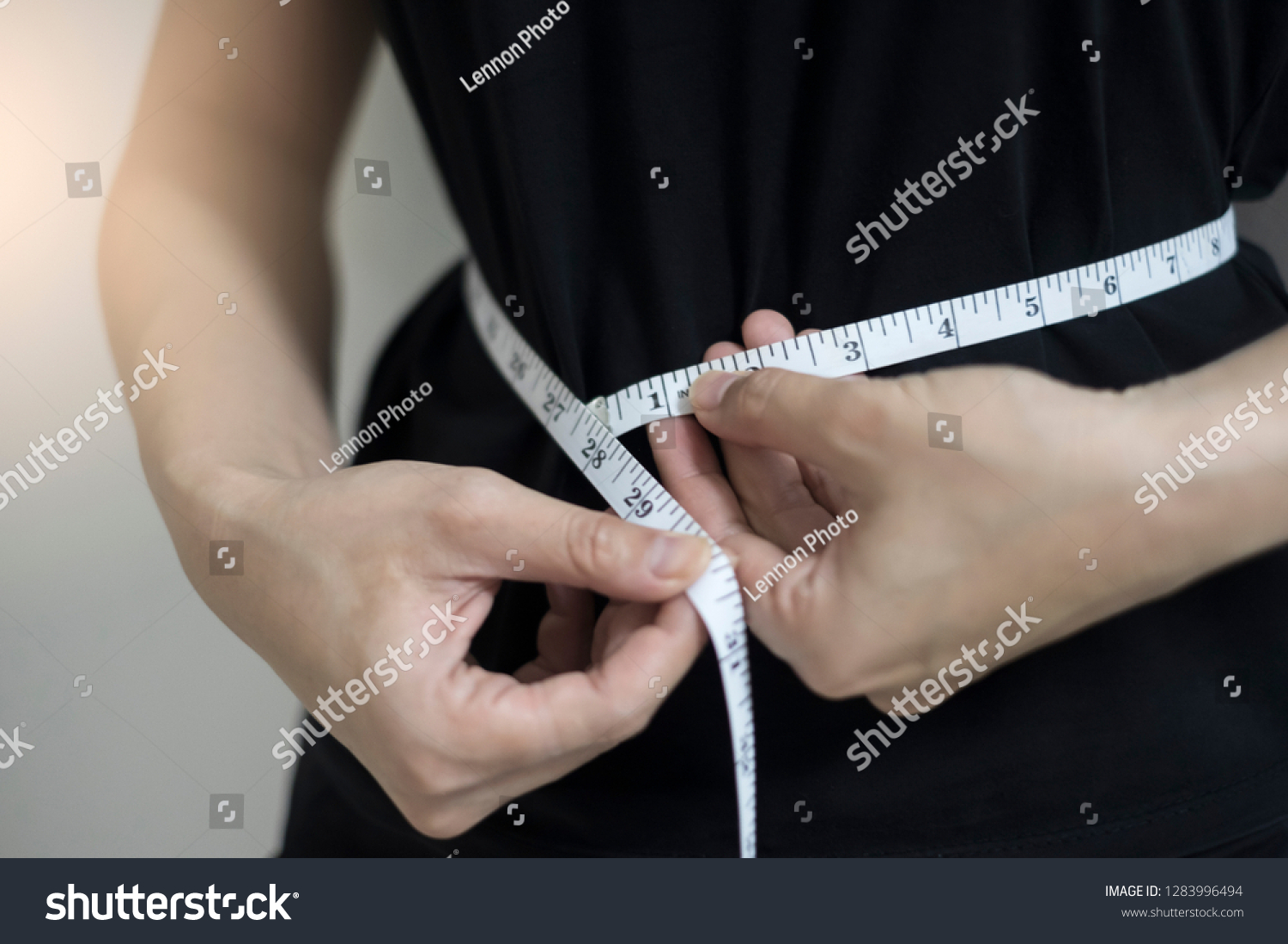 Diet concept close up women measuring waist circumference. #1283996494