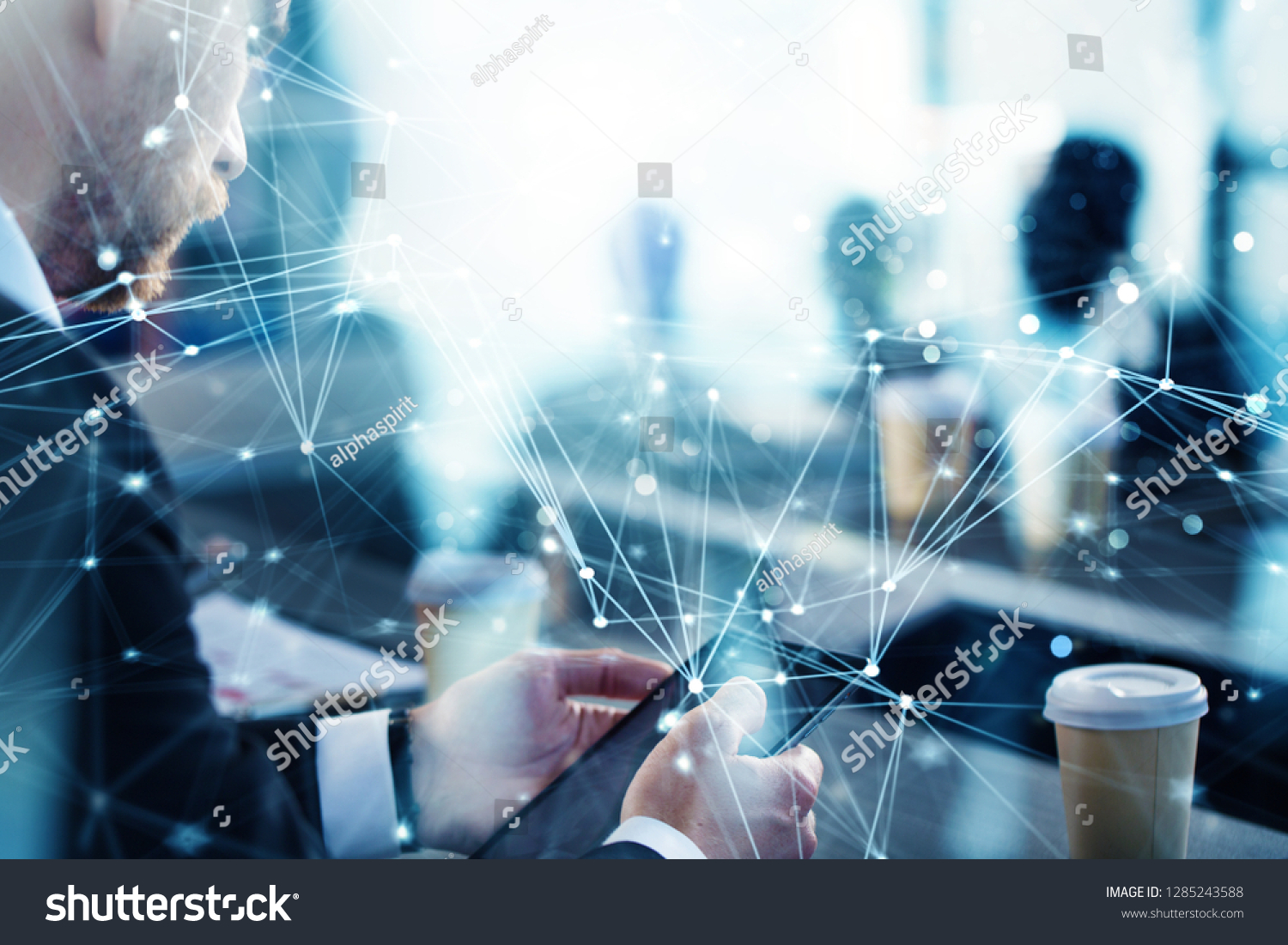 Business man works in office with tablet in the foreground. Concept of teamwork and partnership. double exposure with network effects #1285243588