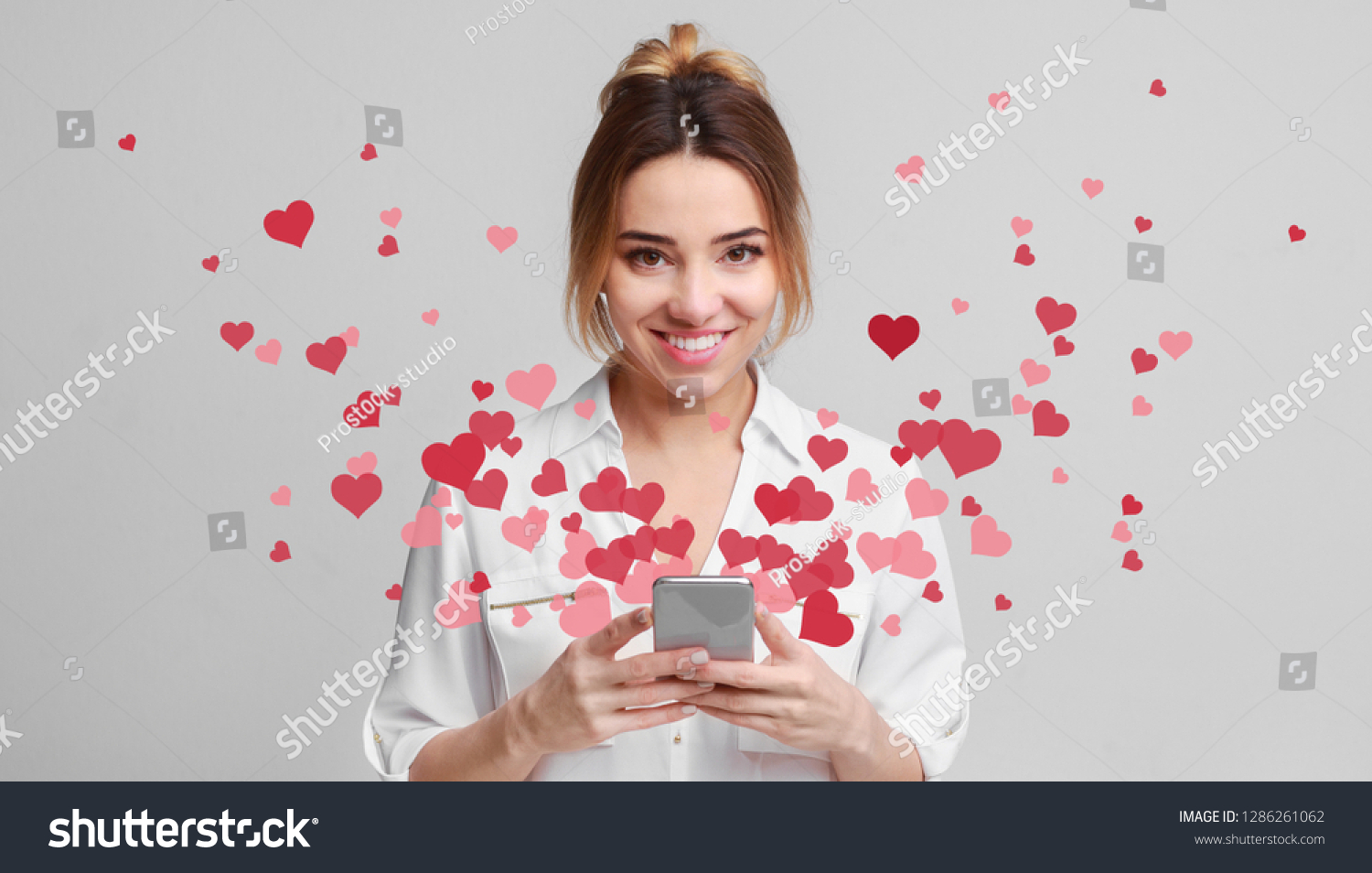 Valentine day concept, love message - hearts flying out smartphone in womans hands #1286261062