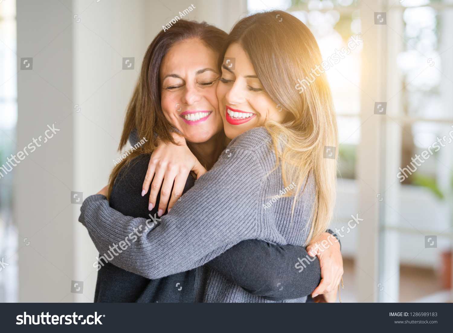 Beautiful family of mother and daughter together, hugging and kissing at home #1286989183