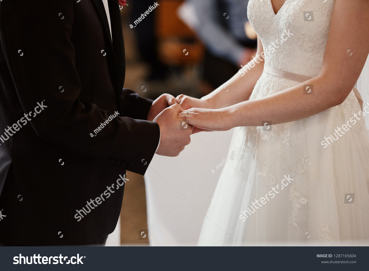 
a young couple holding hands in a church #1287165604