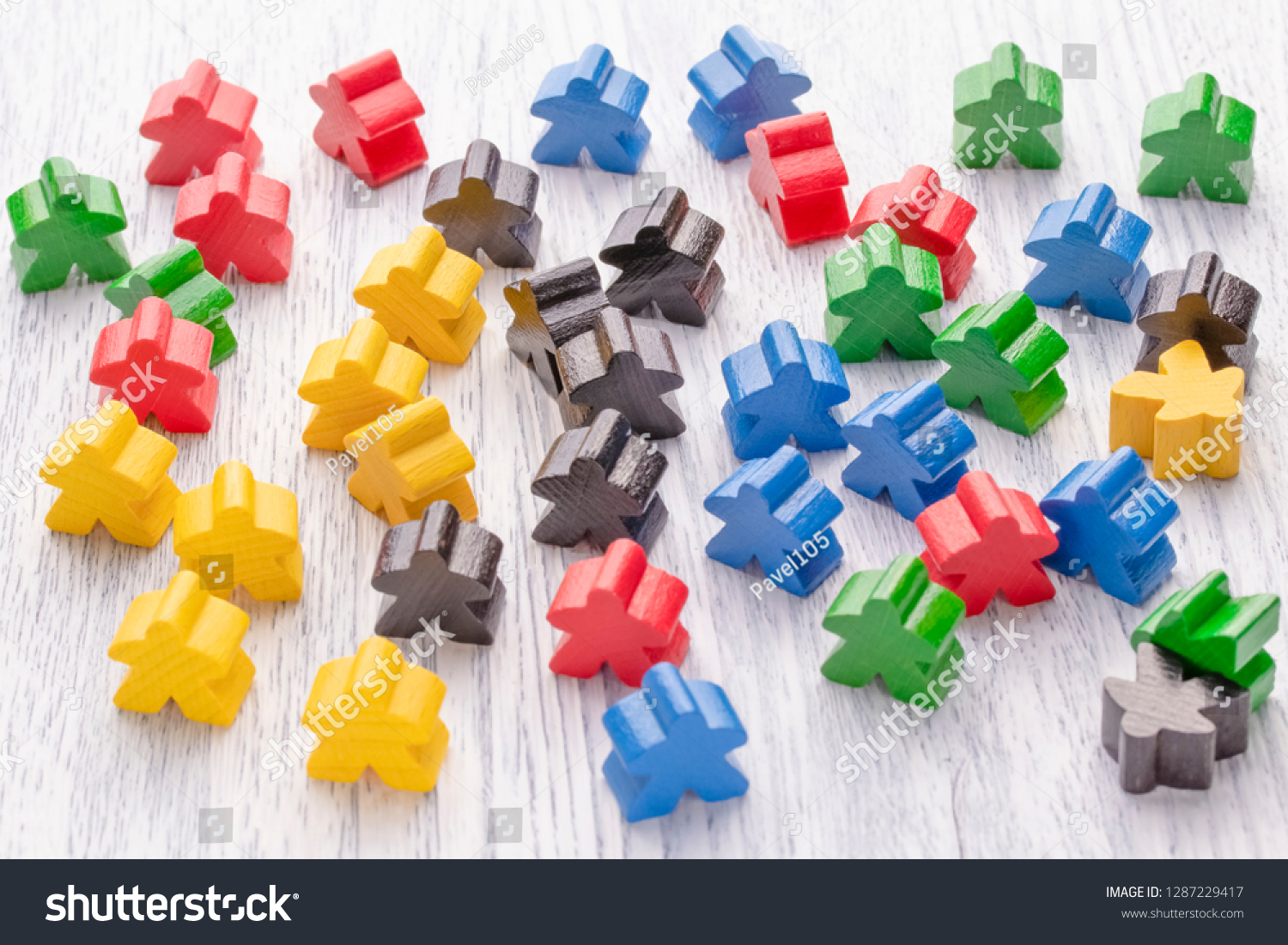 Multicolored wooden figures in the form of stars. Parts of the board game. Leadership skills. The development of logic. Number one, winner and loser. Back and front background in blur. #1287229417