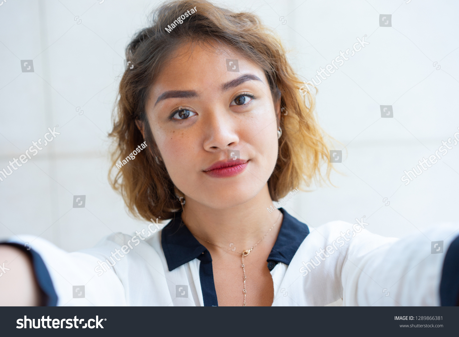 Self portrait of beautiful Chinese girl walking outdoors. Closeup of young attractive woman looking at camera. Selfie concept #1289866381