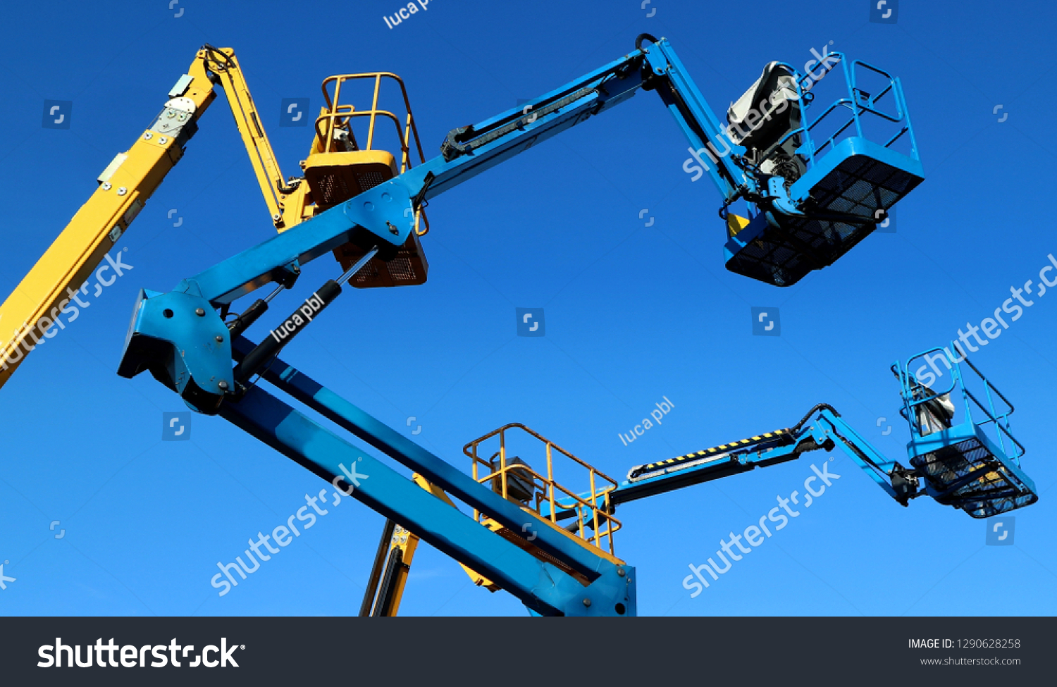 Aerial working platforms of cherry picker against blue sky #1290628258