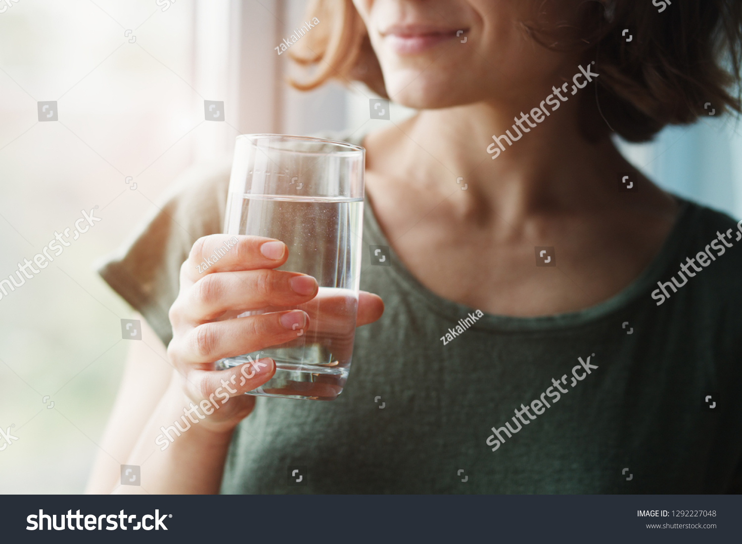 healthy beautiful young woman holding glass of water  #1292227048