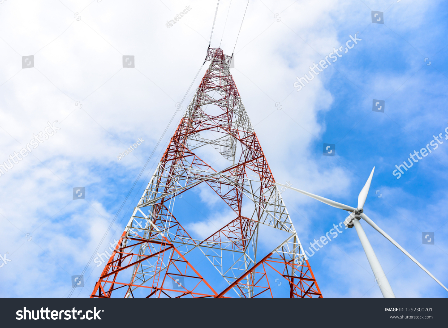 red and white high voltage post,High voltage tower and wind turbine for electric production on blue sky background #1292300701