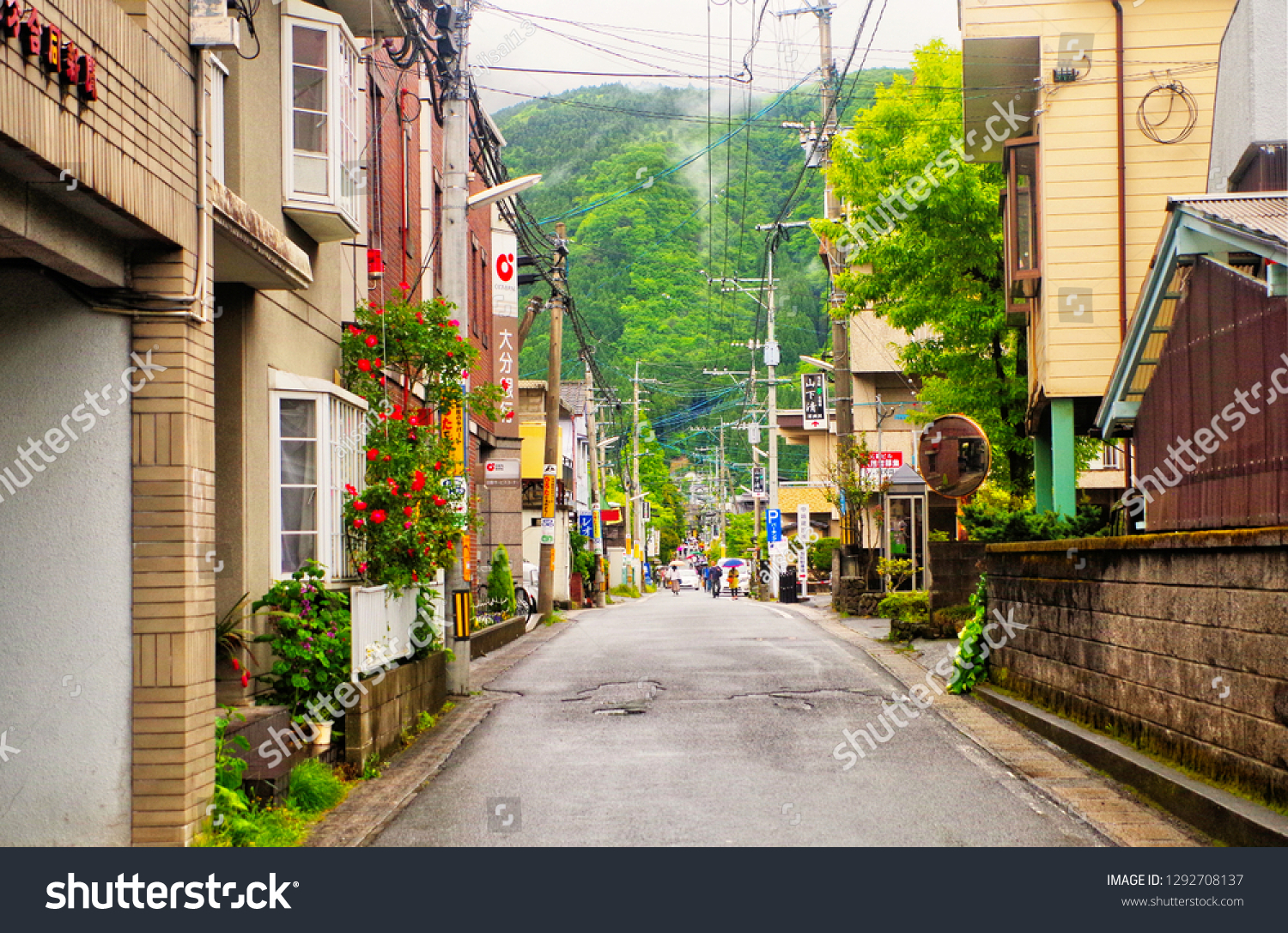 Yufuin ,Yufu ,Oita ,Japan - May 9th,2015 : Cityscape view of narrow street alley with Mount Yufu (Yufudake) background in small peaceful town calls Yufuin village where has Kinrinko Lake is located #1292708137