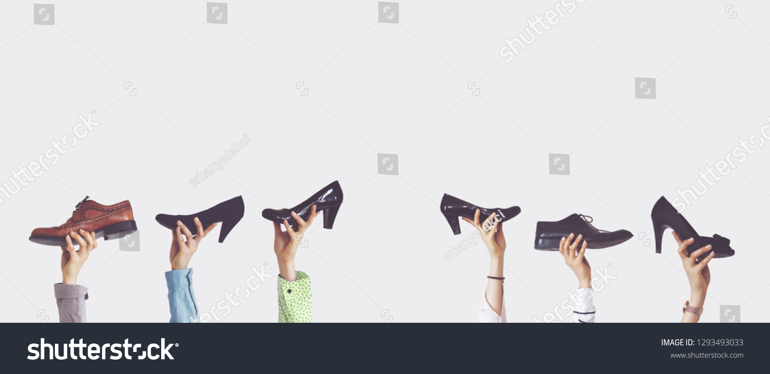 Hands holding different shoes on isolated background #1293493033