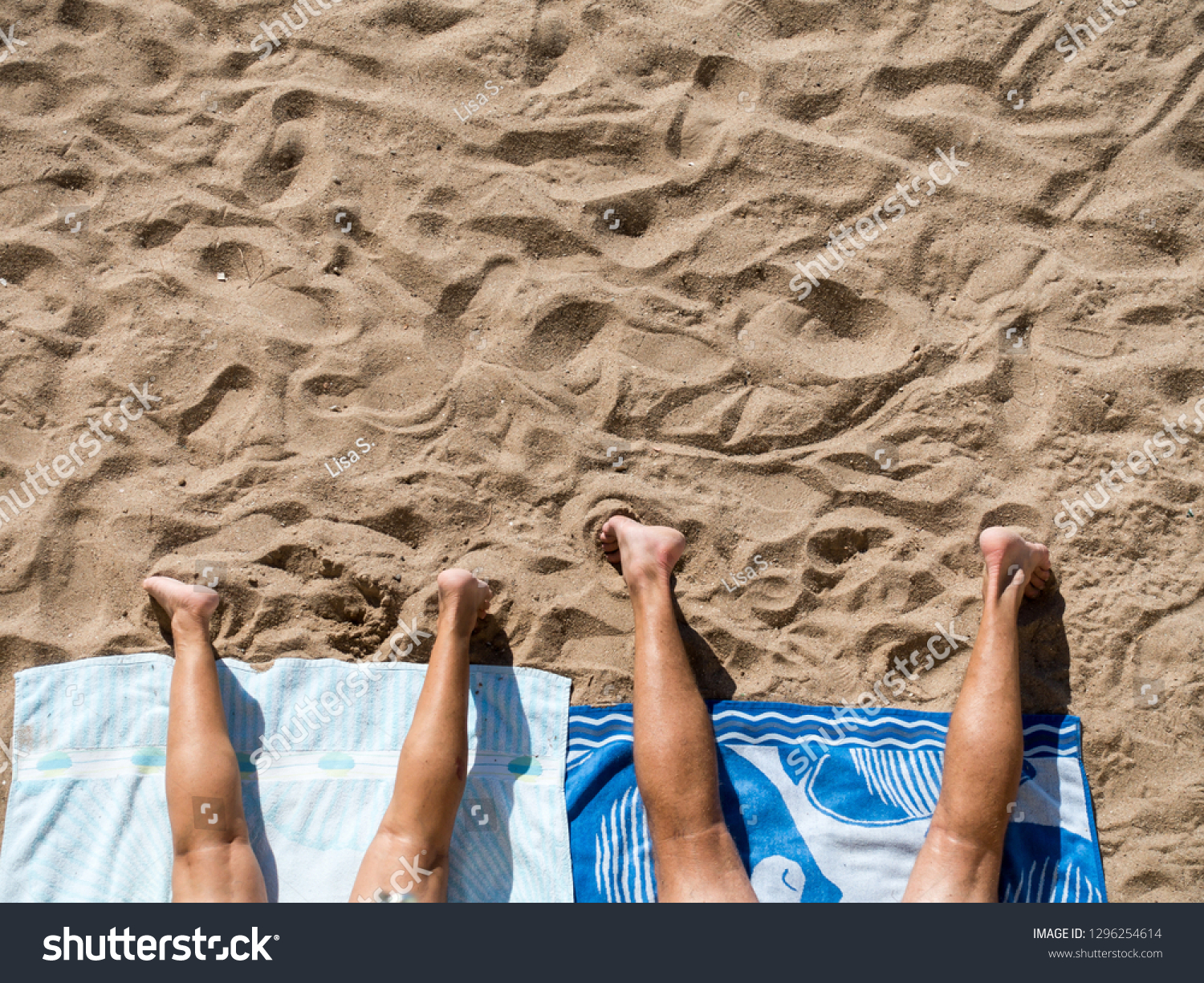 couple sunbathing on the beach #1296254614
