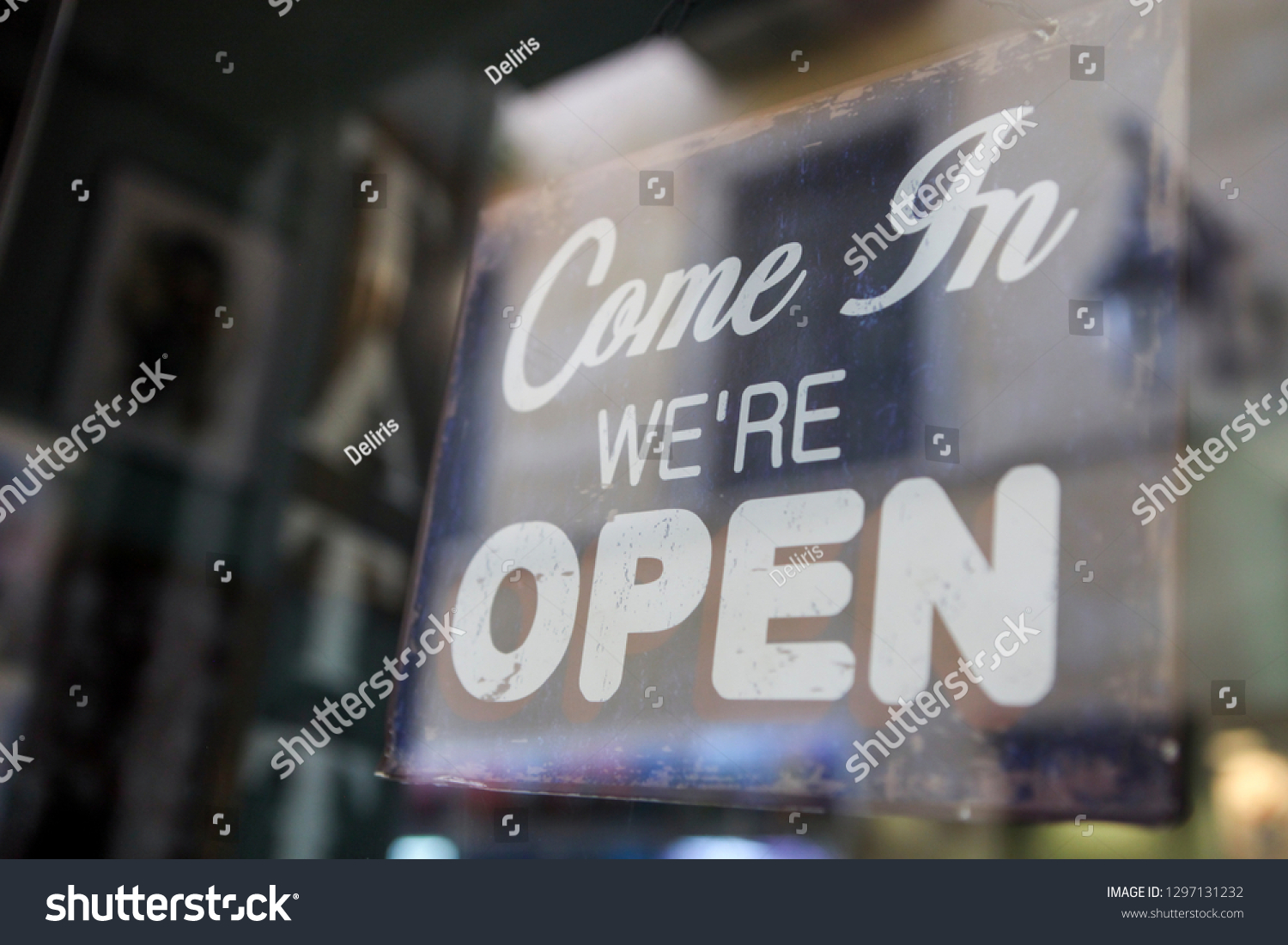 "Come in we are open" sign board through the glass of store window.  #1297131232