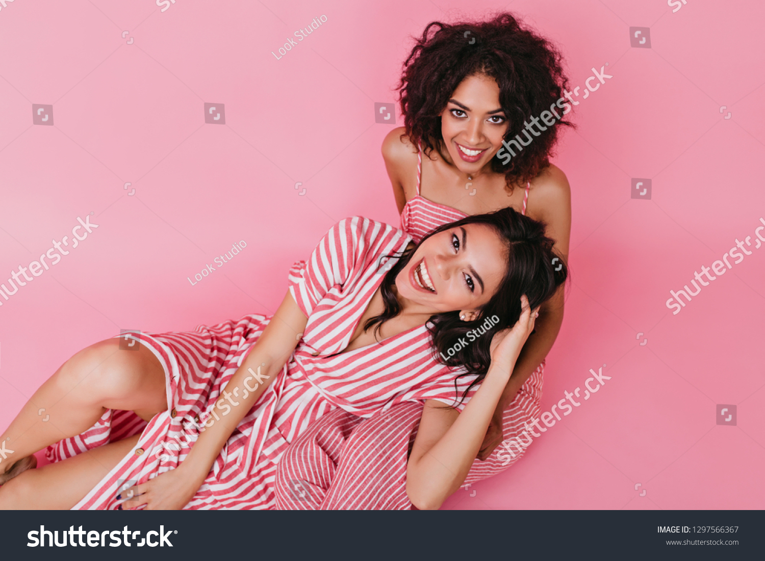 Beautiful girls posing in good mood and having fun on isolated pink background #1297566367