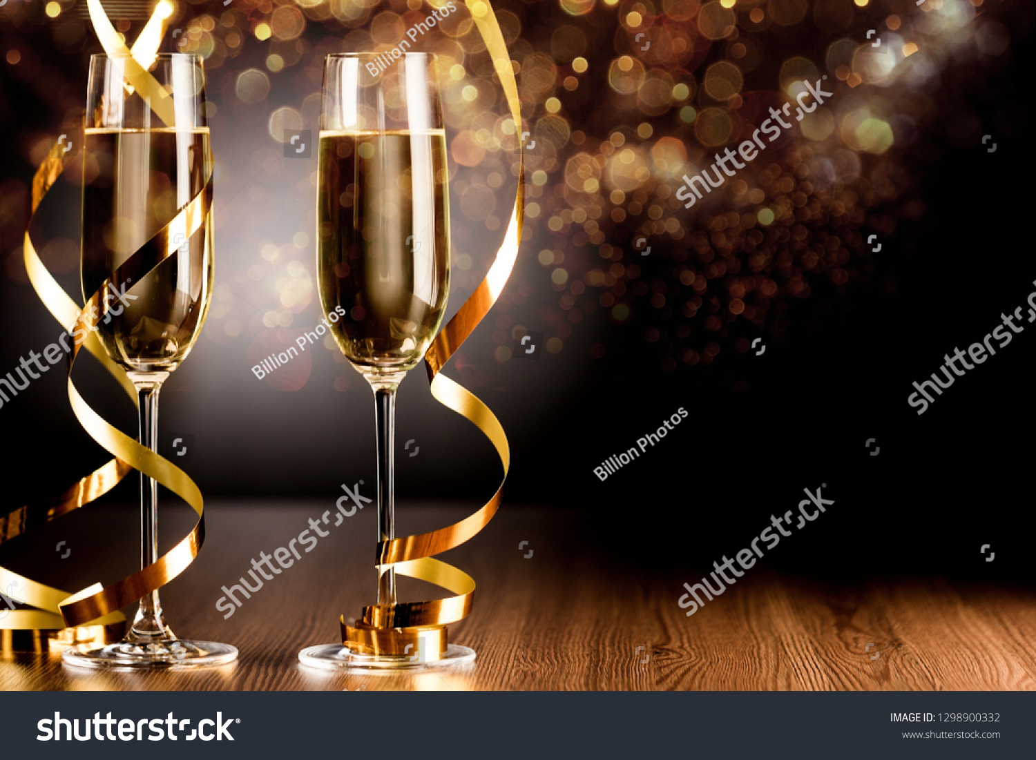 Glasses of champagne with curly ribbon  on wooden table #1298900332