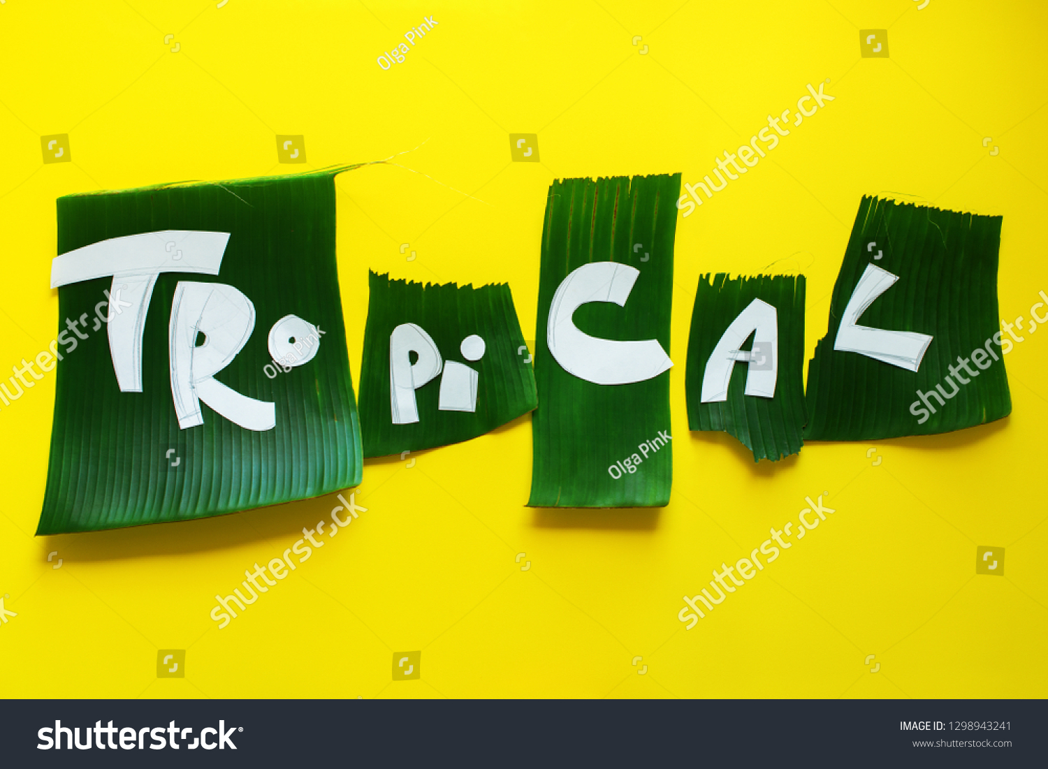 Stage of creation stencil. Word TROPICAL letters from green tropical palm leaves on yellow textured background. Original idea from natural material for summer design #1298943241