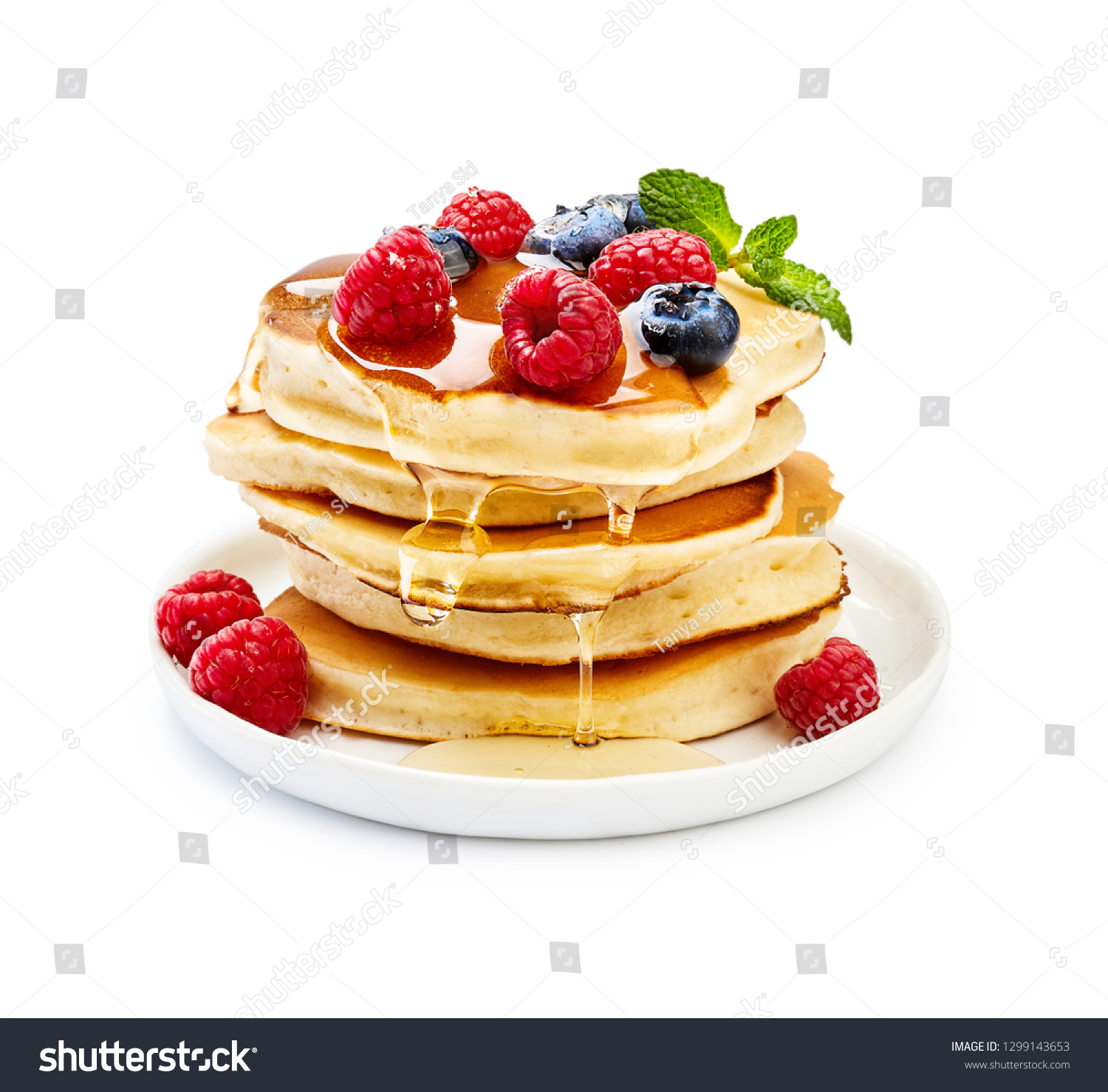 Delicious pancakes with berries, honey or maple syrup. Homemade pancakes and sweet syrup on white plate isolated. #1299143653