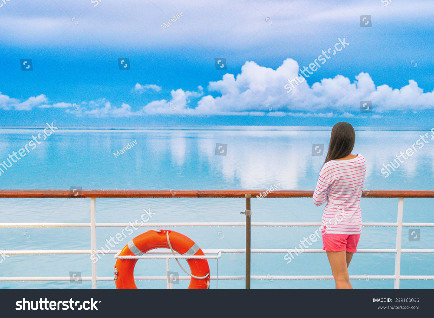 Cruise ship luxury travel woman on deck looking away in Tahiti. Serene still ocean water landscape. Tourism vacation holidays in French Polynesia. #1299160096