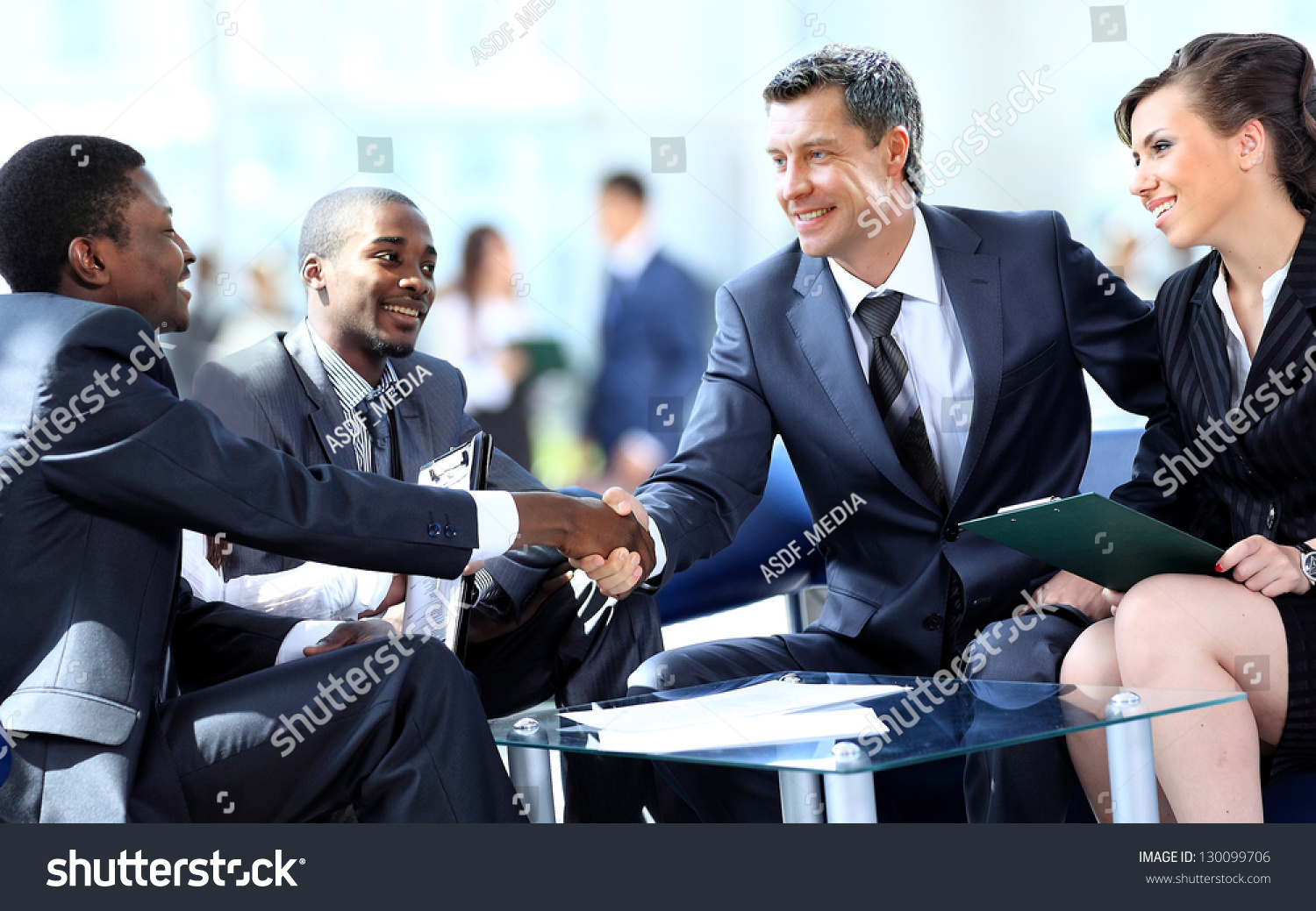 Business people shaking hands, finishing up a meeting #130099706