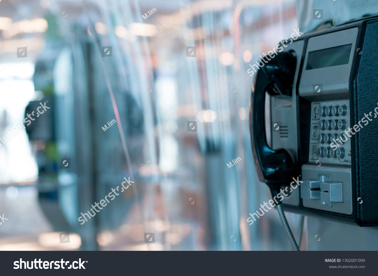 Public payphone in an airport building and blur background #1302001099
