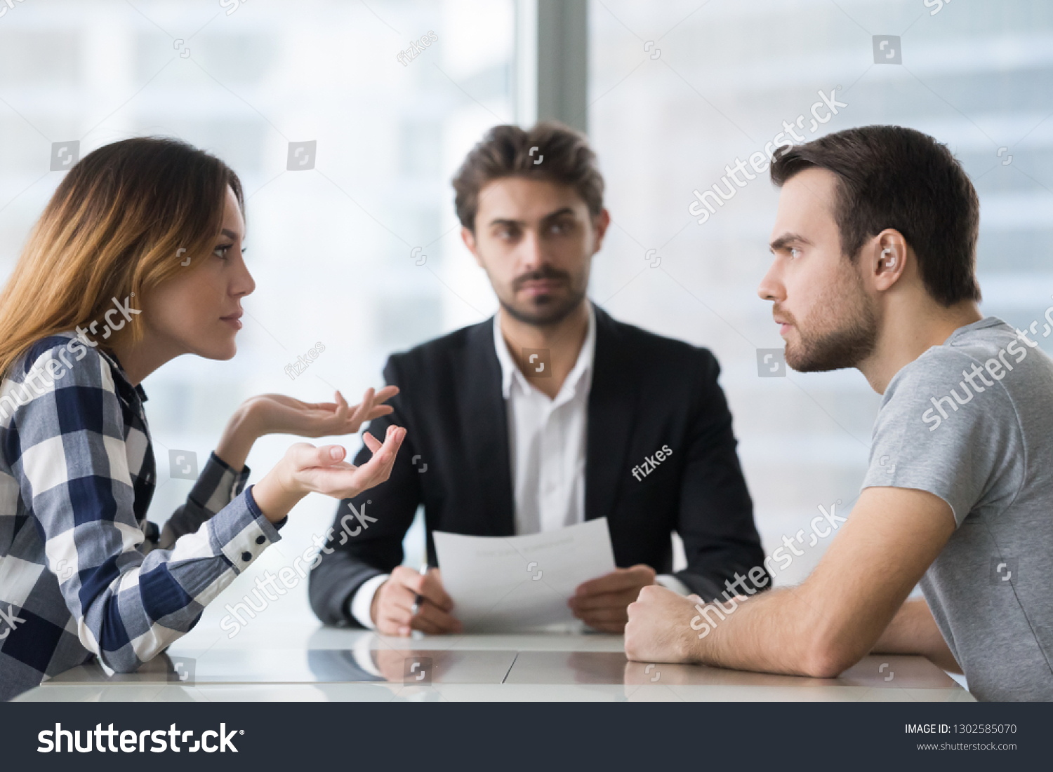 Annoyed unhappy married couple arguing in lawyers office get divorced, angry family spouses split up having disagreement disputing about breaking up and divorce settlement, legal separation concept #1302585070