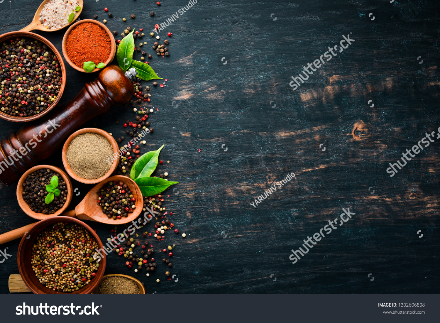 A set of peppers. Black pepper, colored pepper, ground pepper, dried chili pepper. Top view. On a black background. free space for your text. #1302606808