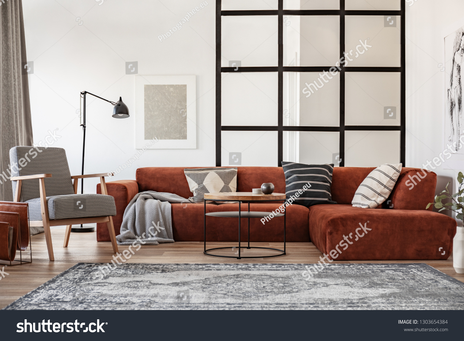 Silver painting on white wall of elegant living room interior with brown corner sofa with pillows #1303654384