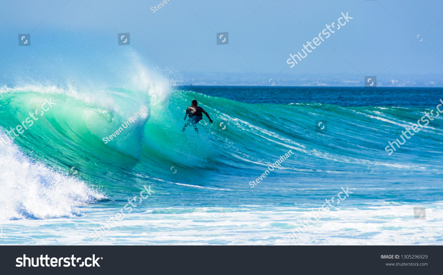 Uluwatu Bali, Indonesia - August 26 2014 : Unknown surfer riding a wave on a  beautiful sunny day. #1305296929