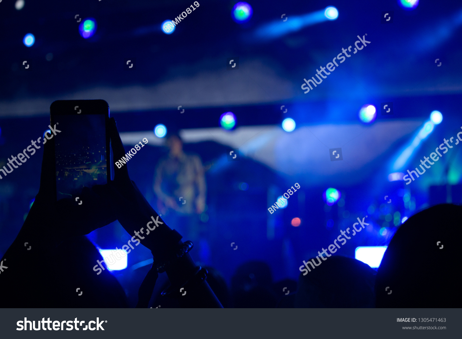Hand with a smartphone records live music festival, Taking photo of concert stage, live concert, music festival #1305471463