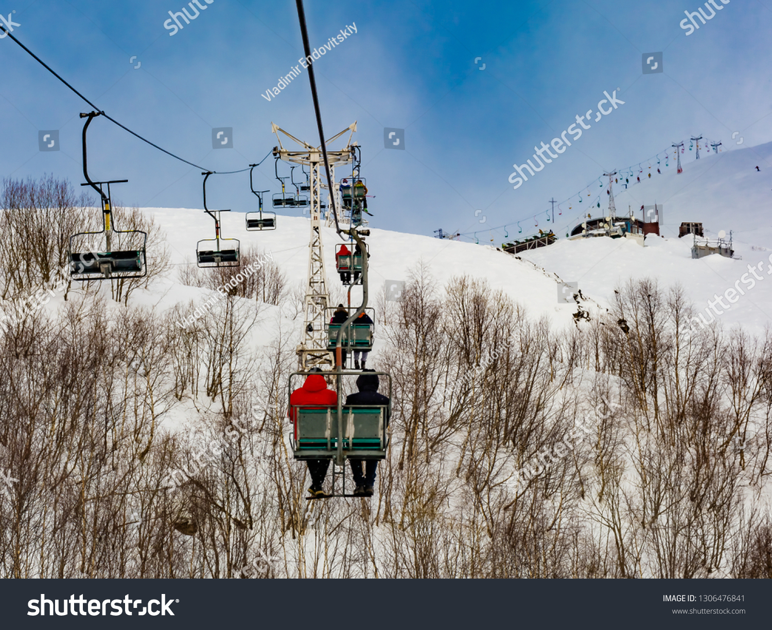 Extreme cable car ride. Winter holidays in the mountains. Snow-covered mountain slopes. Skiers and tourists. #1306476841
