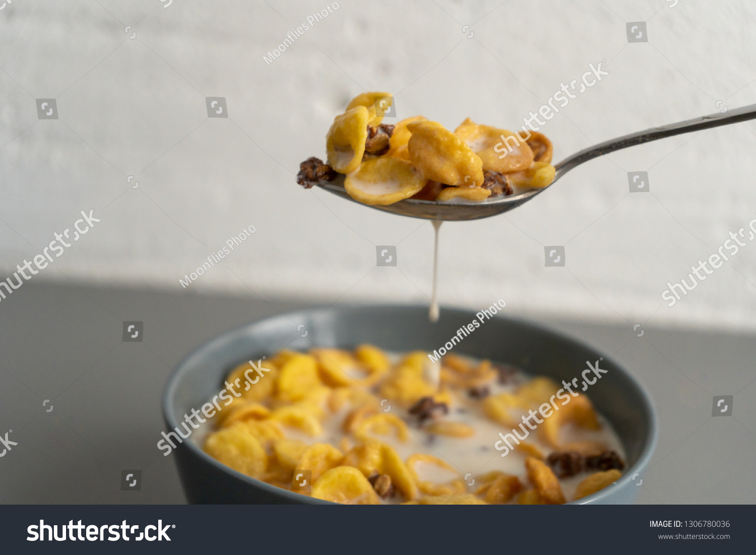 Spoon with cornflakes and milk #1306780036