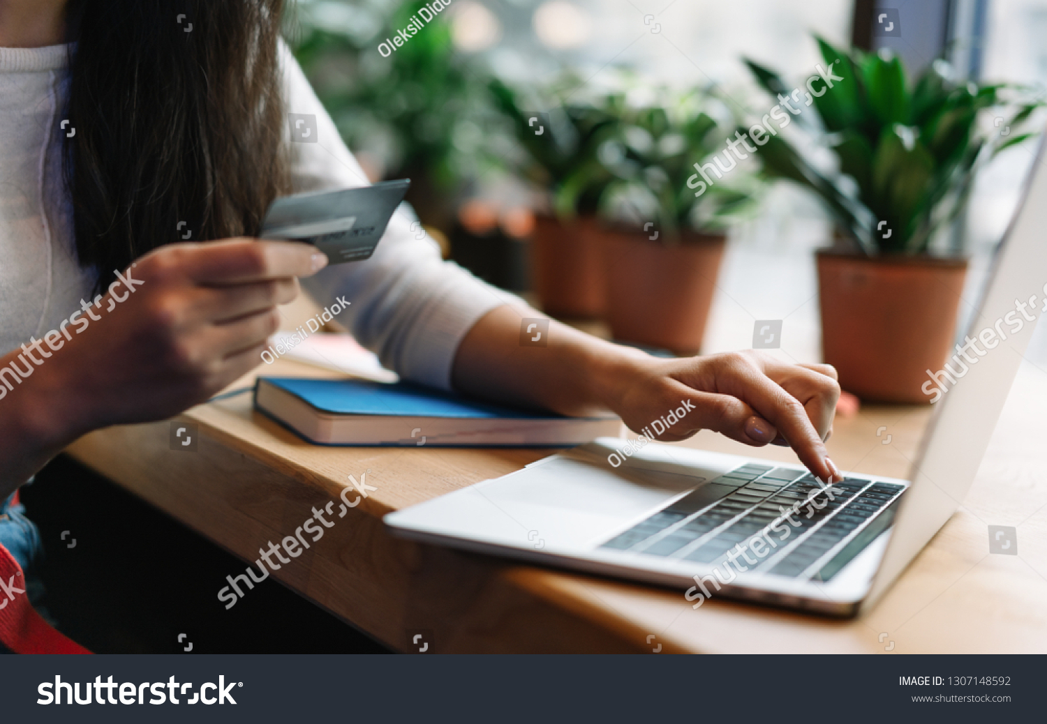 Close up woman's hand holding credit card using laptop computer for online shopping with cash back, discount sales, low prices. Online store concept. Female planning travel and booking tickets. #1307148592