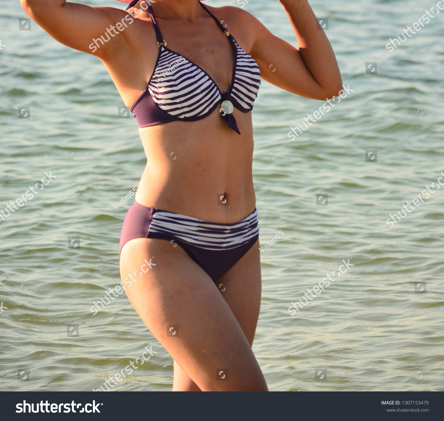 Woman on vacation posing for a photographer at the sea #1307153479