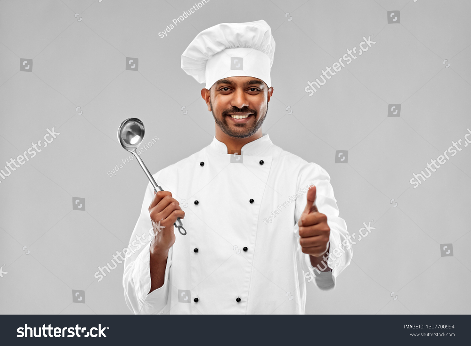 cooking, profession and people concept - happy male indian chef in toque with ladle showing thumbs up over grey background #1307700994