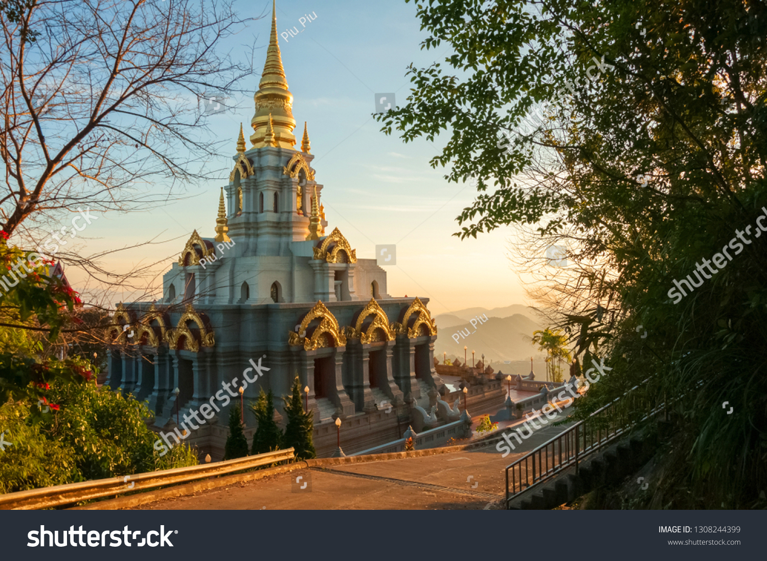 Wat Santikhiri Temple in Doi Mae Salong in Northern Thailand at beautiful warm sunrise light with mist in the mountains at the background #1308244399