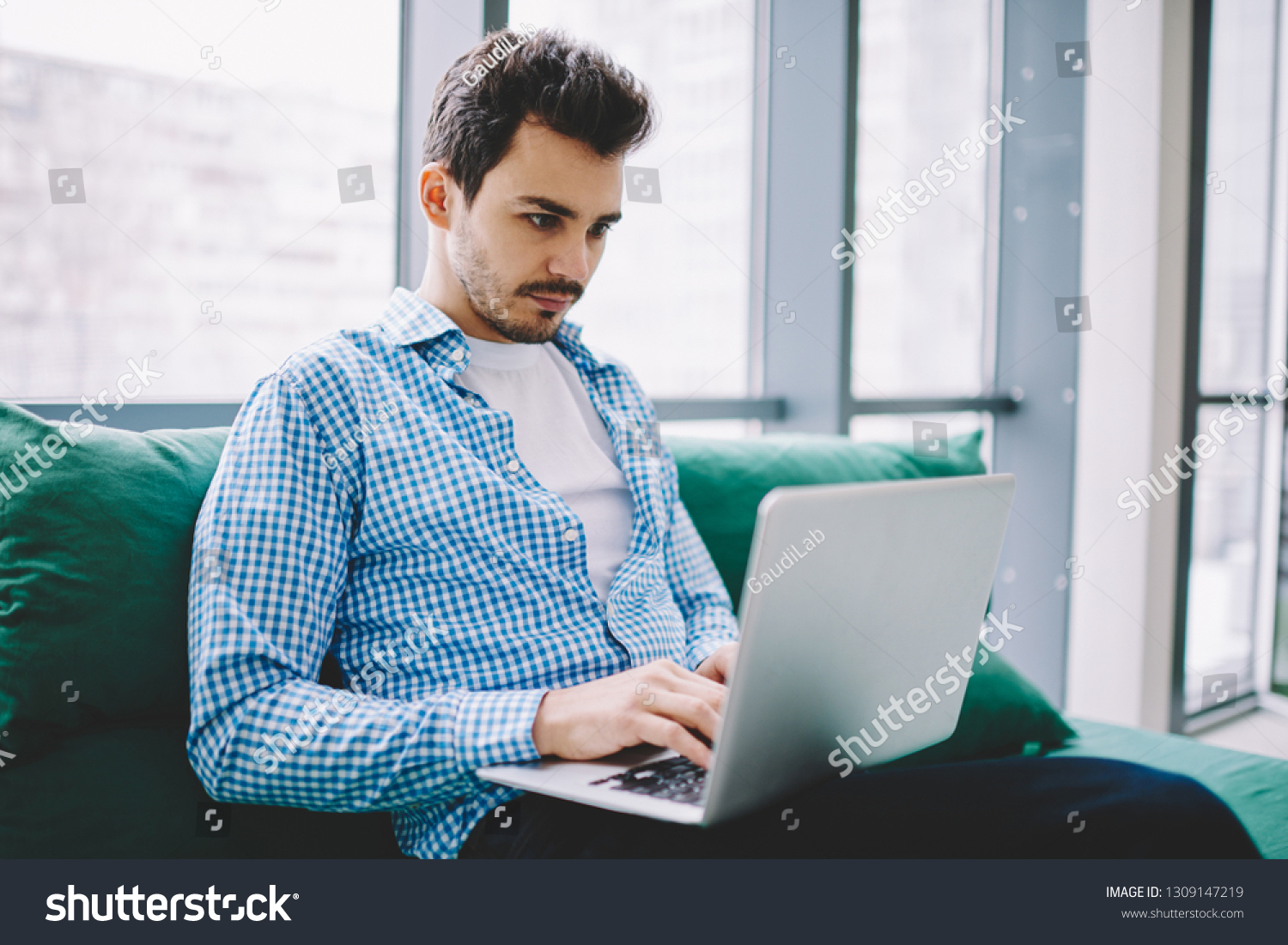 Serious male software developer working remotely on modern laptop device watching tutorial webinar online for certification training connected to 4g wireless for browsing internet on netbook #1309147219