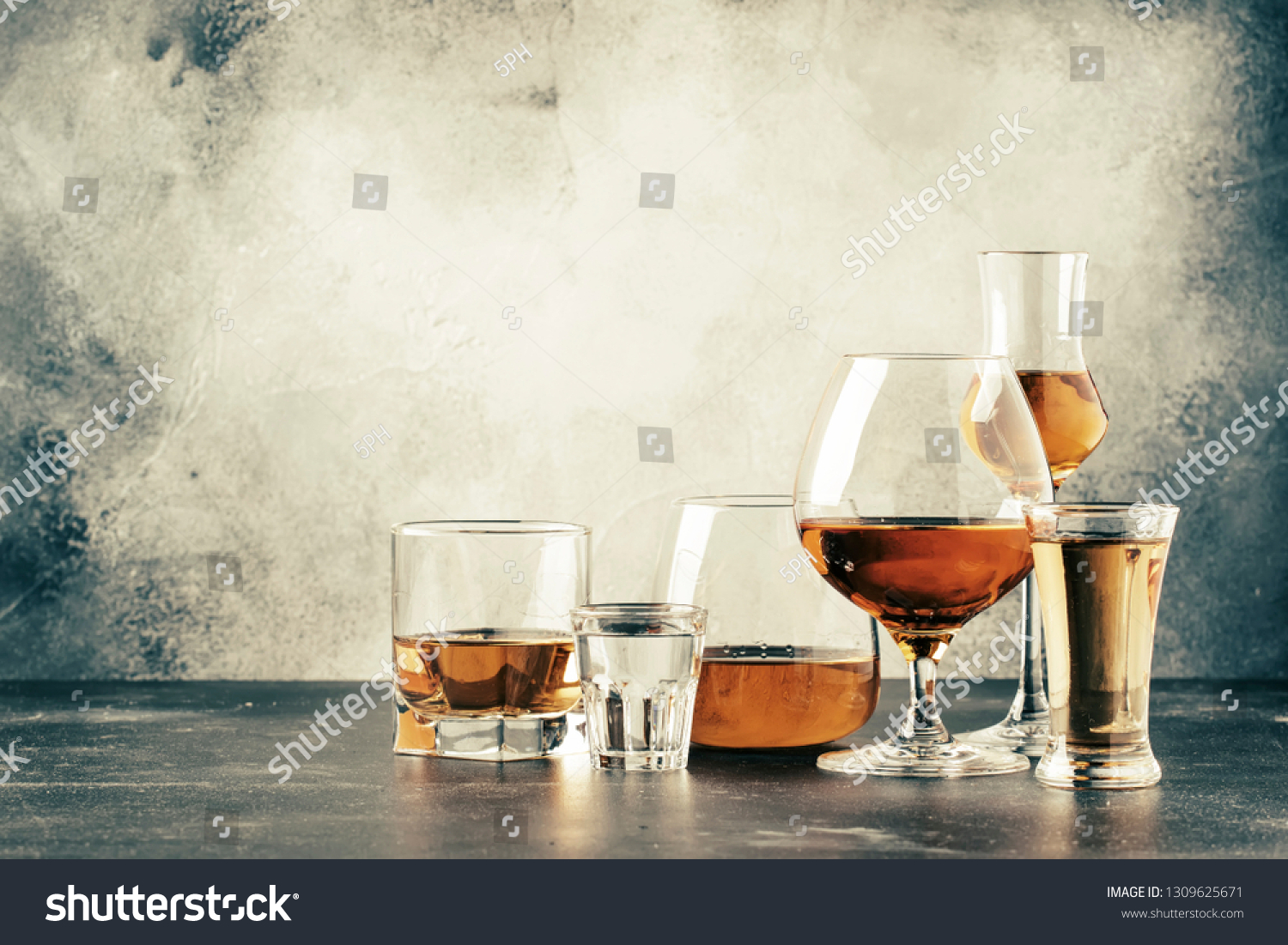Selection of hard strong alcoholic drinks in big glasses and small shot glass in assortent: vodka, cognac, tequila, brandy and whiskey, grappa, liqueur, vermouth, tincture, rum.  #1309625671