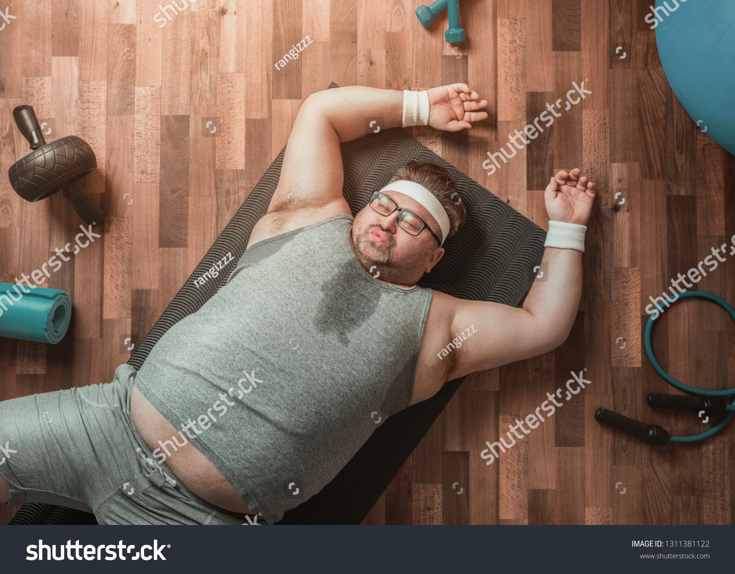 Funny overweight sportsman lying exhausted down on the floor  #1311381122