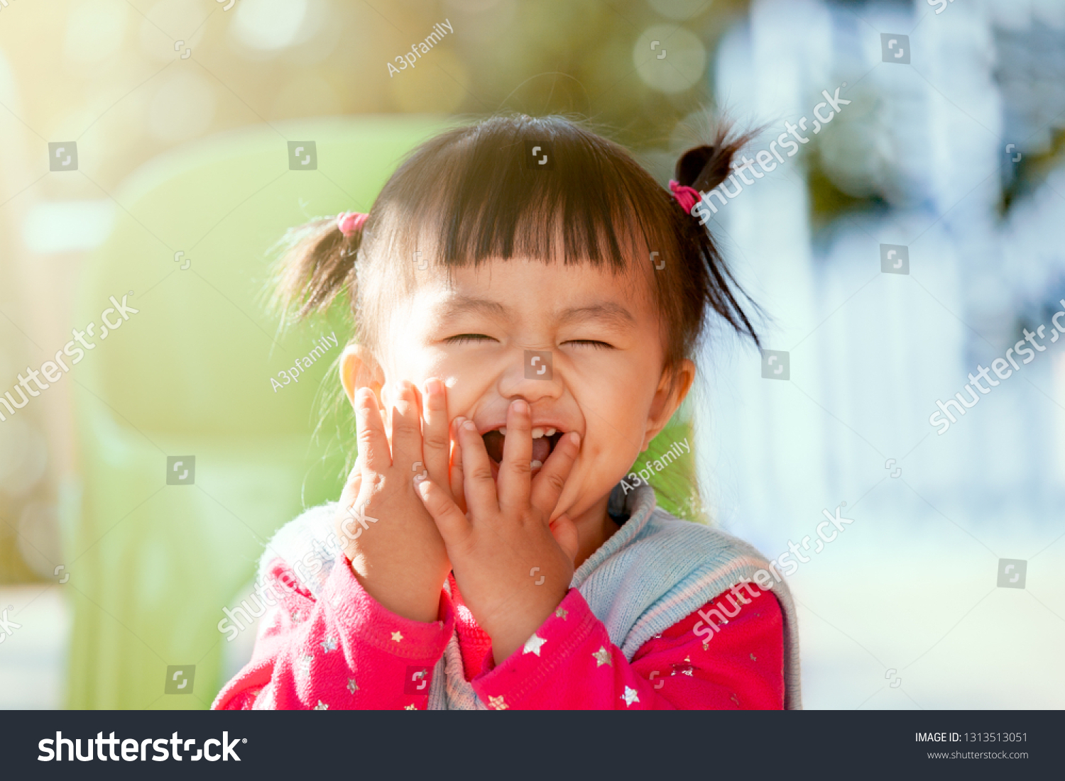 Cute asian baby girl laughing and playing peekaboo or hide and seek with fun #1313513051