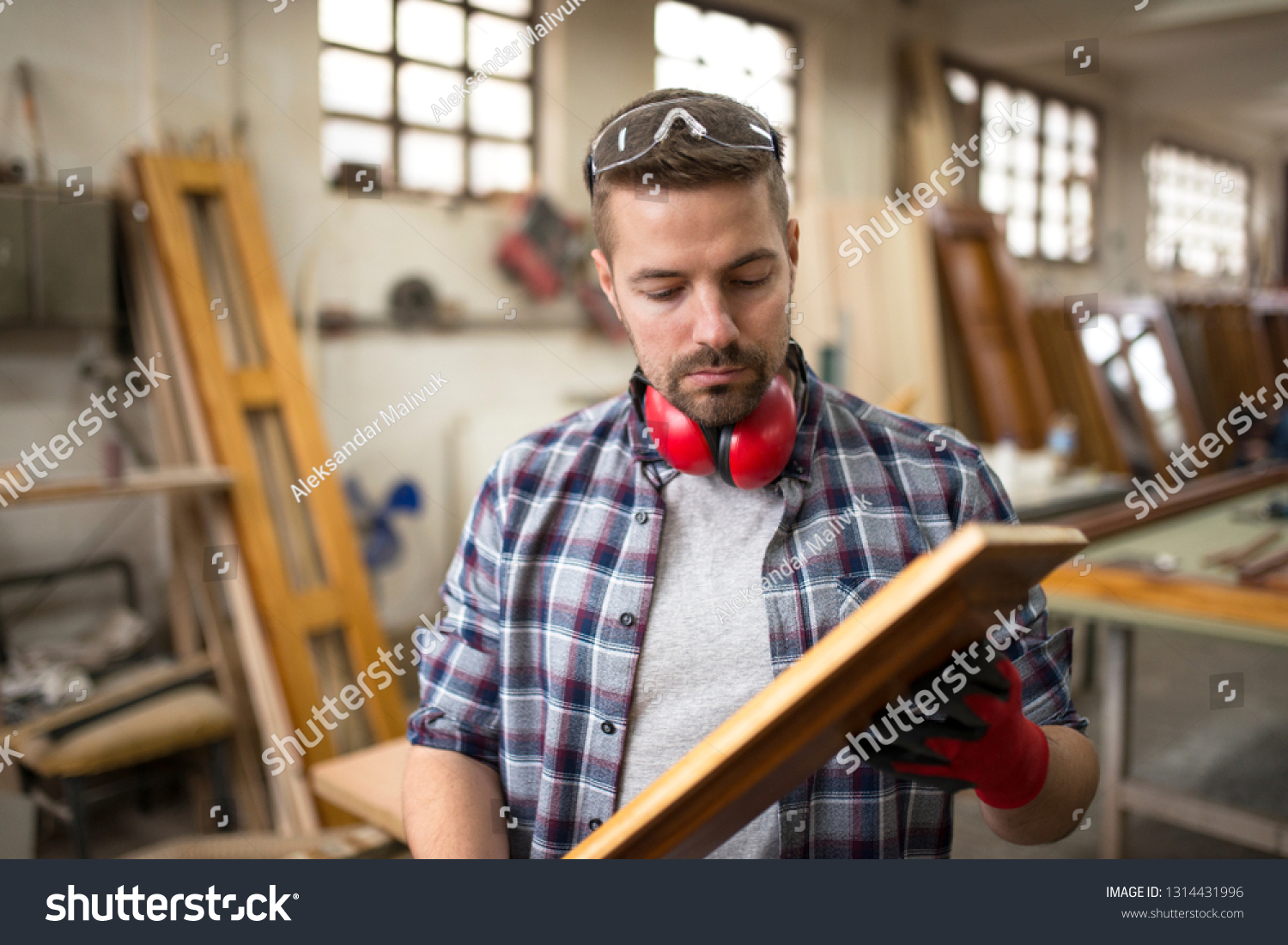Focused professional worker carpenter checking quality of wood product in carpentry workshop. #1314431996