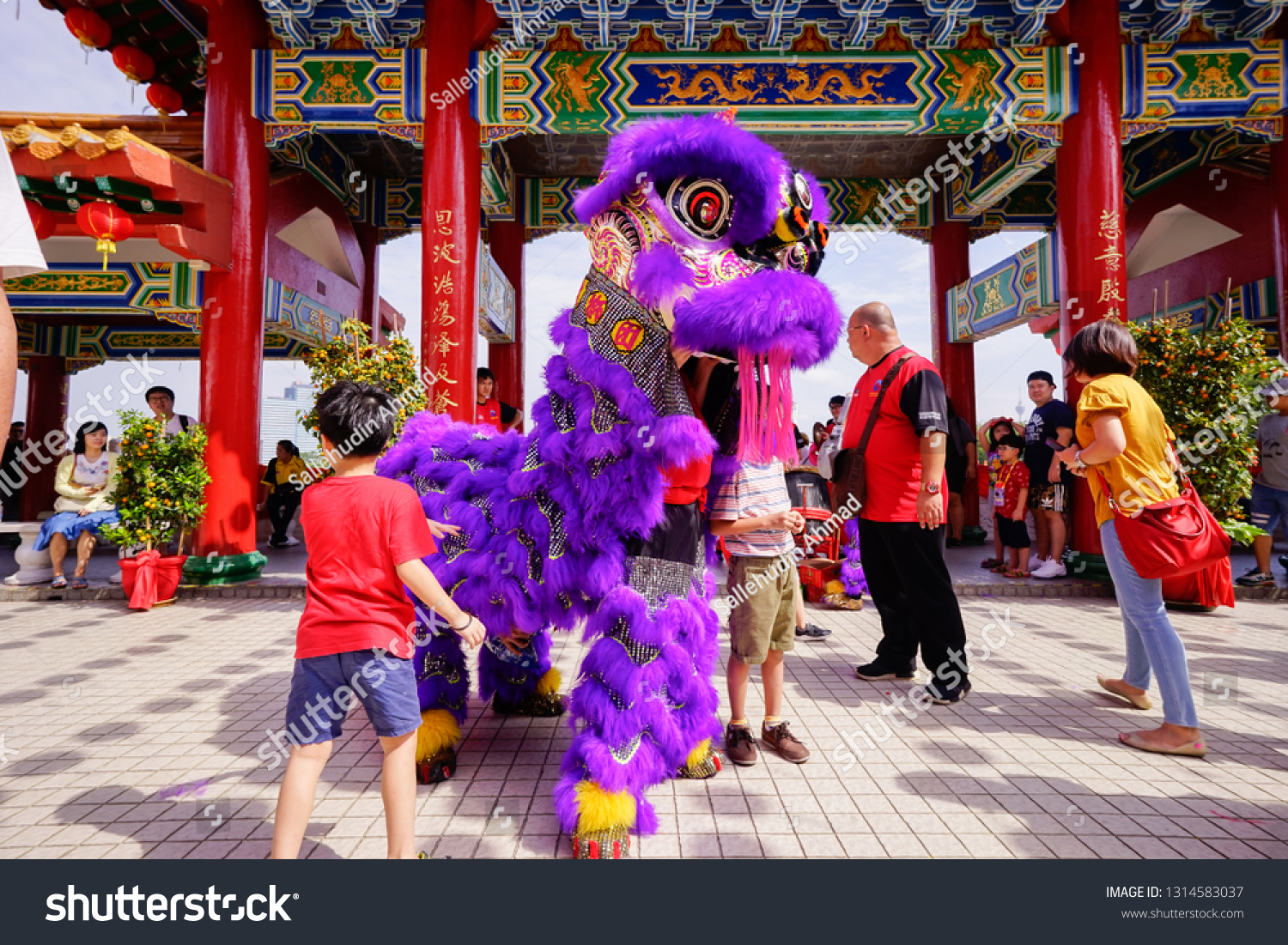 KUALA LUMPUR, MALAYSIA - FEBRUARY 2019 : People do not miss the opportunity to touch and give Ang Pow during Chinese New Year Lion Dance performances at Thean Hou Temple. #1314583037