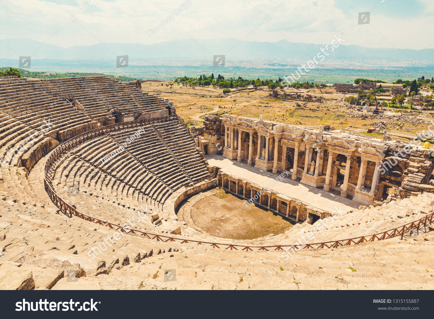 Panorama ancient Greco Roman city. Ruins of ancient city of old amphitheater, Hierapolis in Pamukkale, Turkey. Ruined ancient city in Europe. Is popular tourist destination in Turkey #1315155887