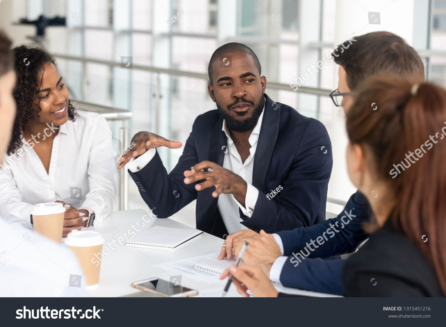 Millennial employees gathered in boardroom for training, black boss ceo leader leading corporate team during seminar learning at modern office. Internship and leadership coaching and education concept #1315451216