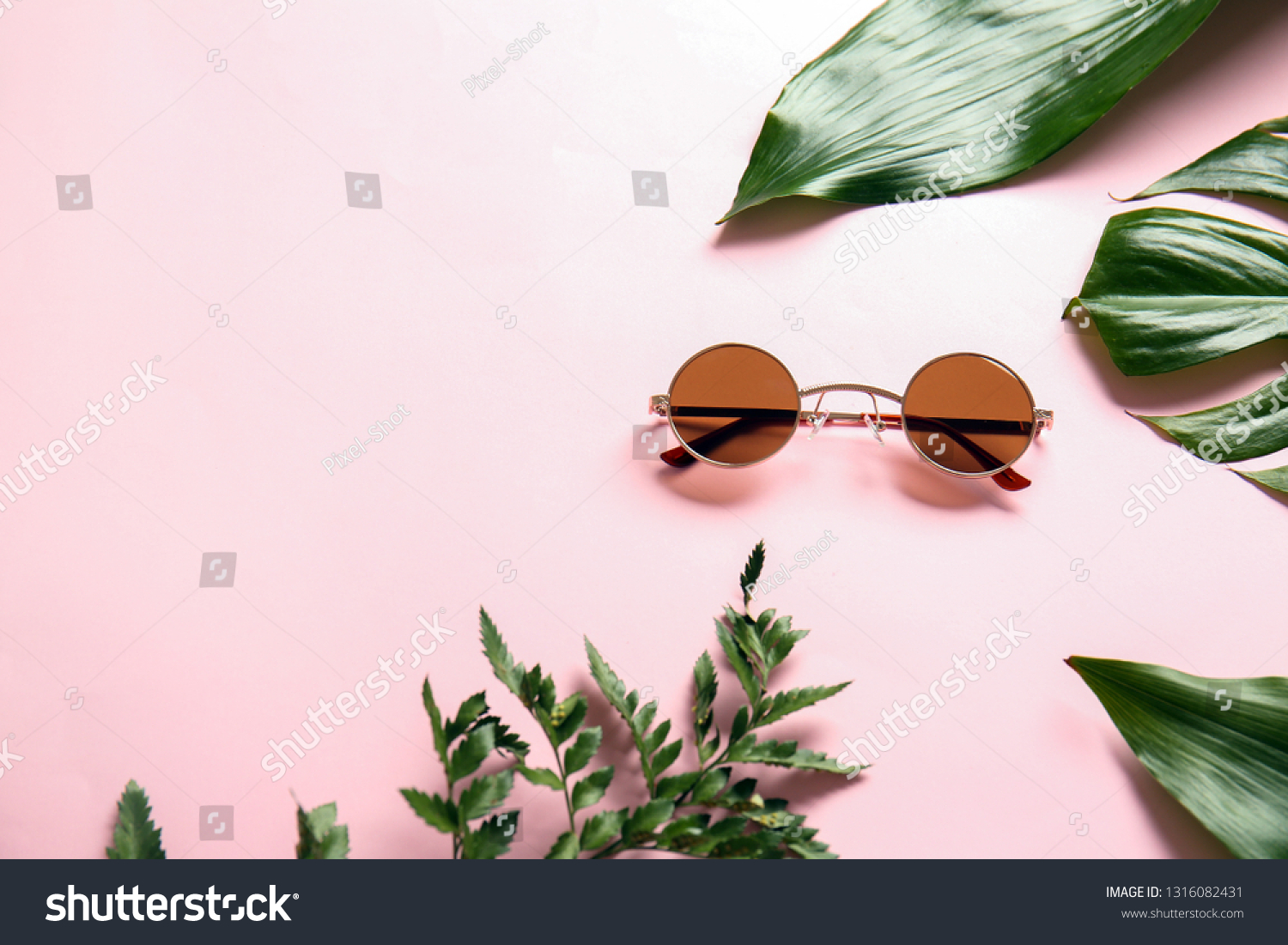 Stylish sunglasses with tropical leaves on color background #1316082431