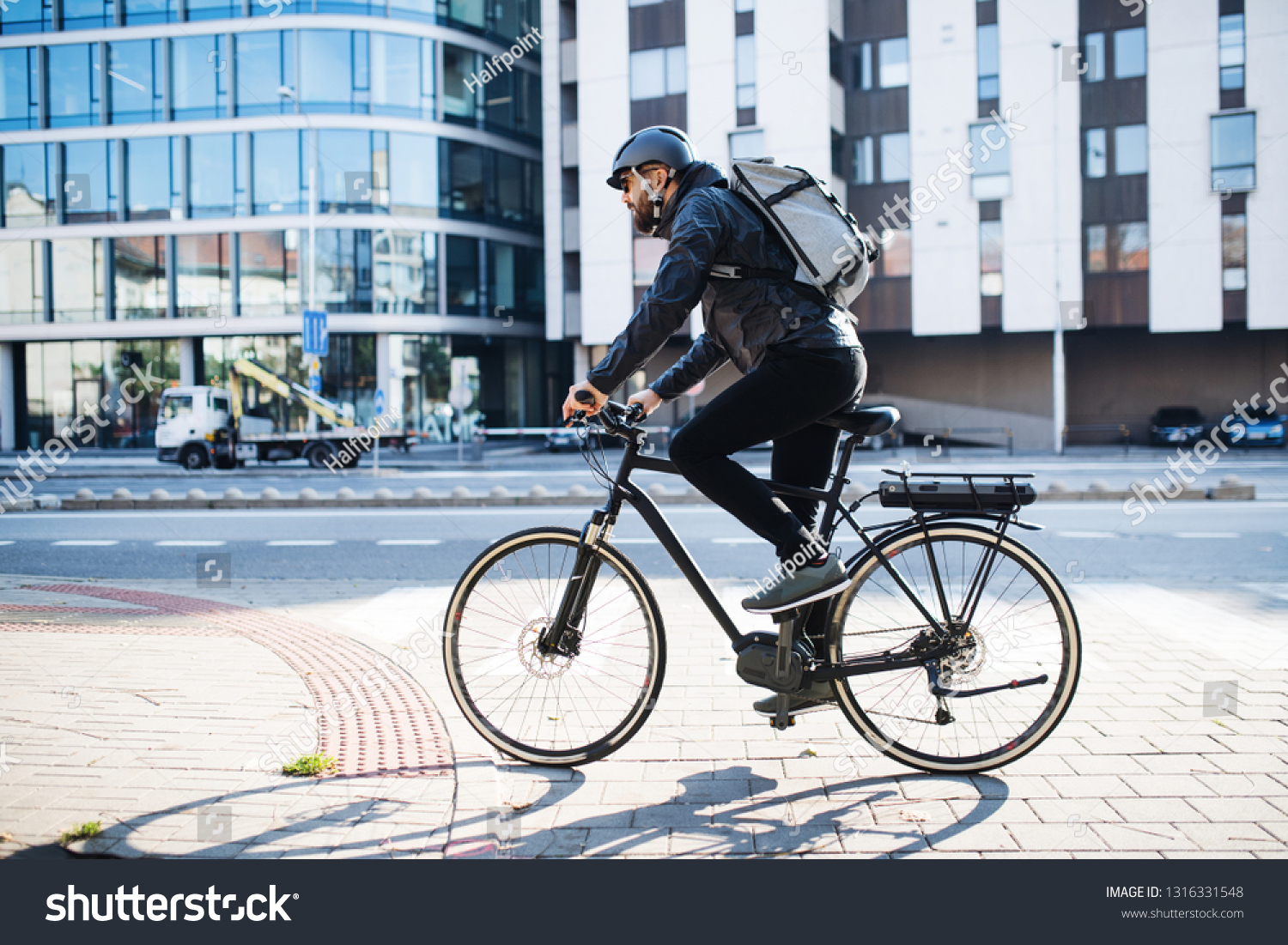 Male courier with bicycle delivering packages in city. Copy space. #1316331548