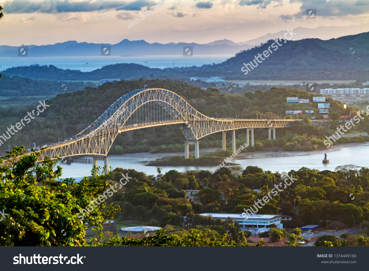 Panoramic aerial view of the Bridge of The Americas over the Panama Canal Pacific Entrance. Sunset scene with a gentle mist in the background. The bridge is spanning two continents - two Americas. #1316449160