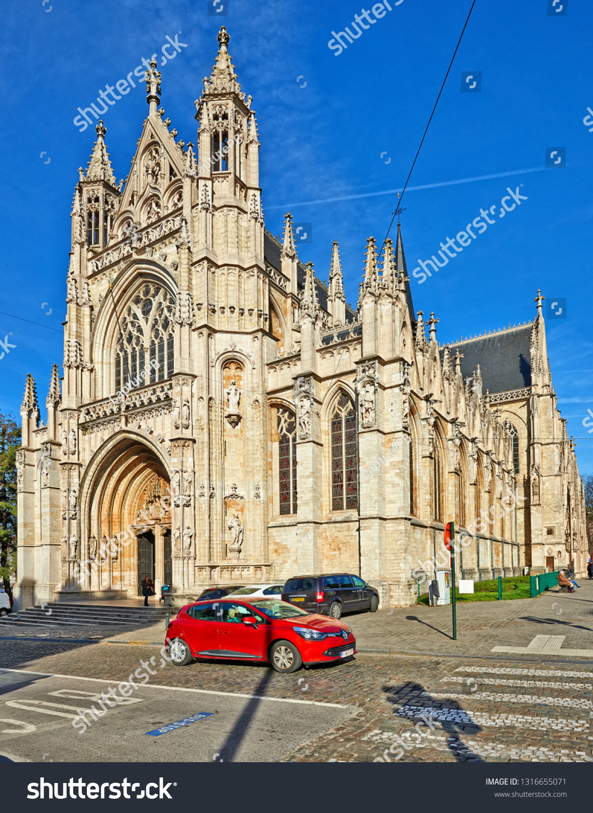 BRUSSELS, BELGIUM - FEBRUARY 17, 2019: Some people enjoy a Sunny winter day at Notre Dame du Sablon's Cathedral in Brussels, Belgium 2019 #1316655071