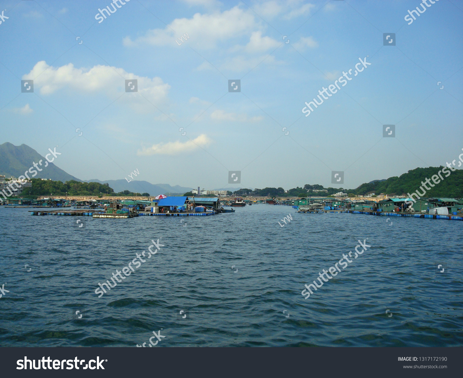 The raft floating fish farming, fish farming raft on the sea, aquaculture farming, Fish Farming Community with the background of beautiful blue sky and sea  #1317172190