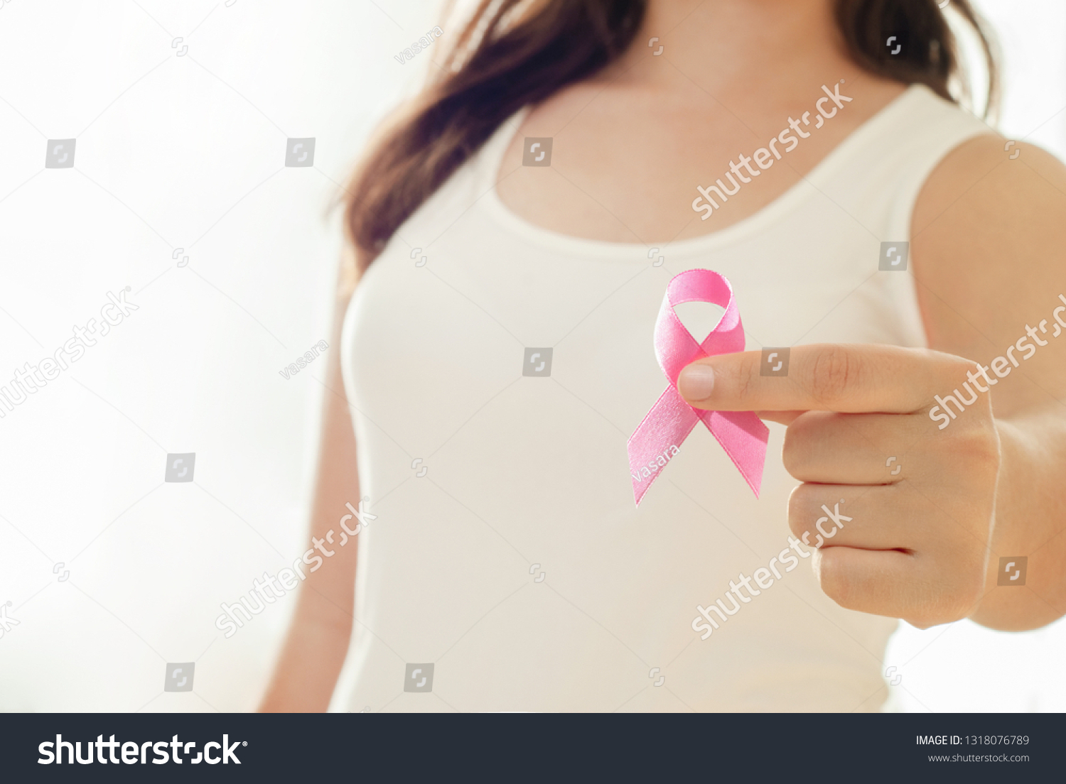 Woman hand holding pink ribbon, breast cancer awareness concept, healthcare and medicine #1318076789