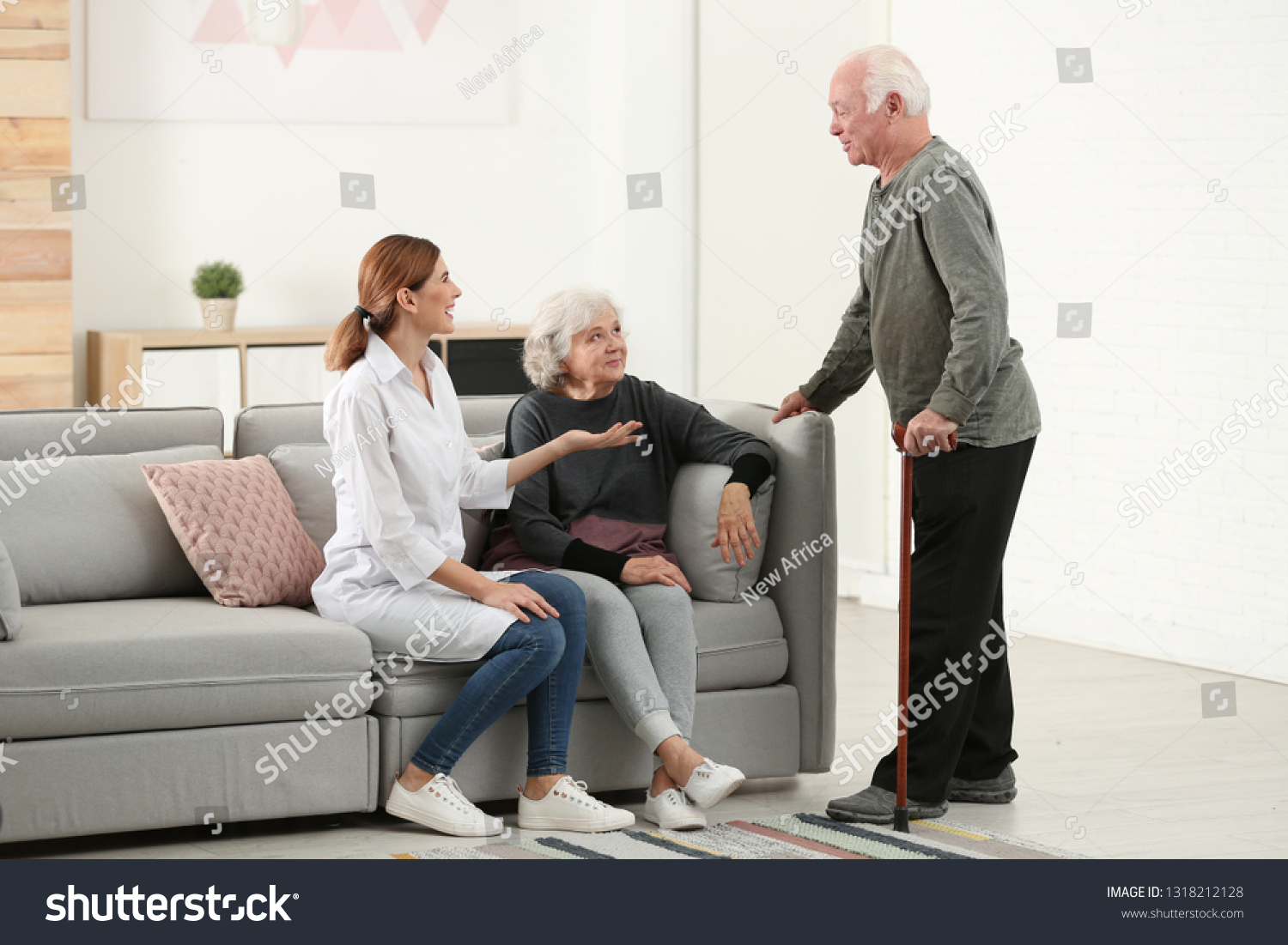 Elderly spouses with female caregiver in living room #1318212128