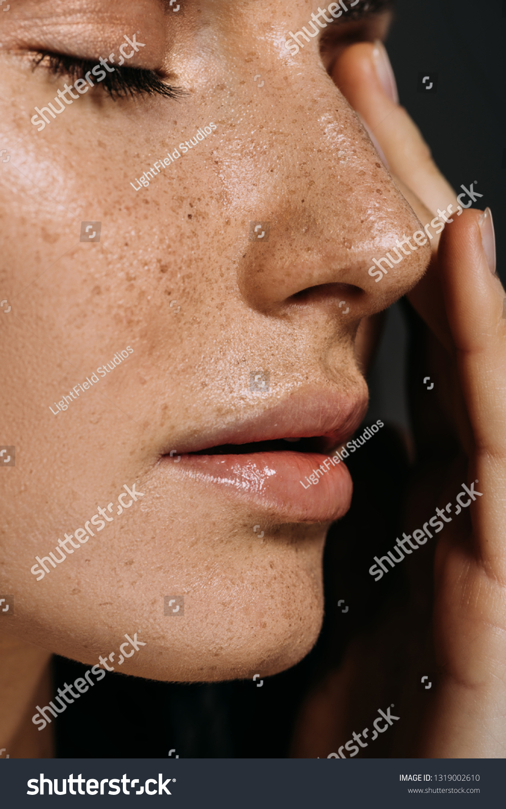 close up view of tender woman with freckles on face isolated on grey #1319002610