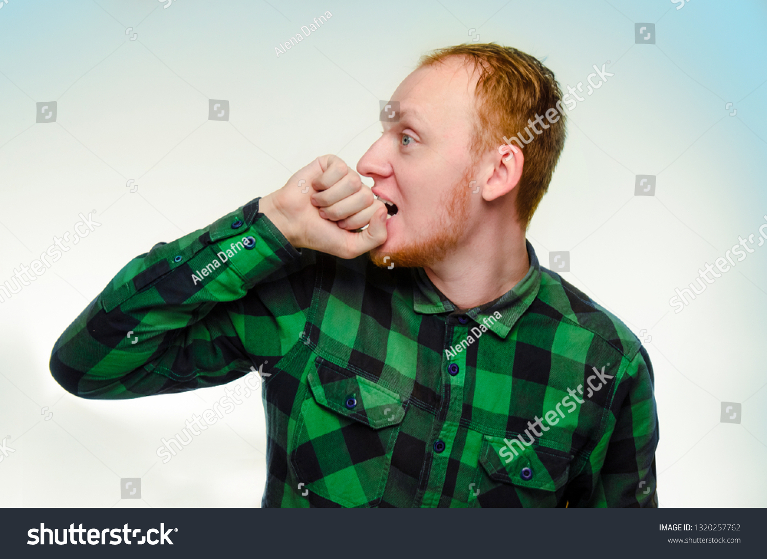 red haired man bite his fist, hand. shocked, caucasian male teenager. surprised redhead guy scream. reaction to surprise is overjoyed shock. emotion is serious, fear, stress. #1320257762